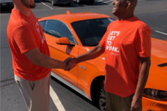 Spherion Works Sweepstakes Winner Michael P. with his new orange Ford Mustang
